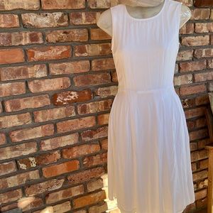 WFFS white lined sleeveless pleated dress. Tailored fit to waist.